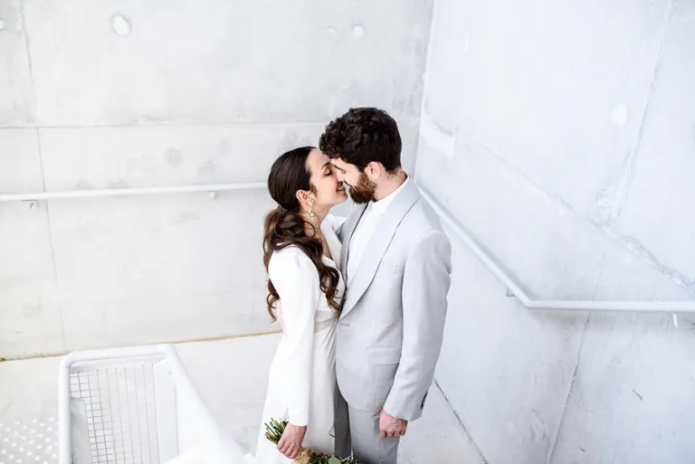 couple portant une robe de mariée et un costume de mariés minimalistes réalisés sur-mesure
